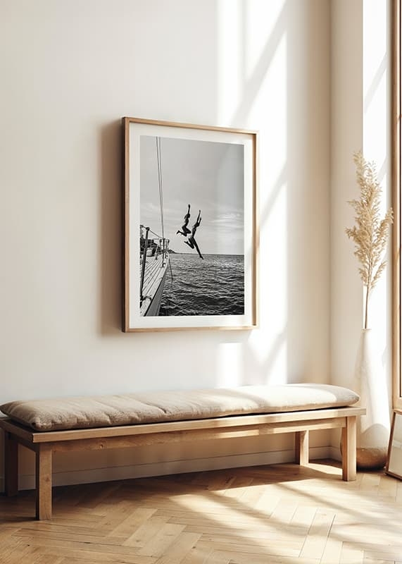 Afiș alb-negru cu o fotografie a doi oameni care sărind de pe o barcă cu pânze în mare-4